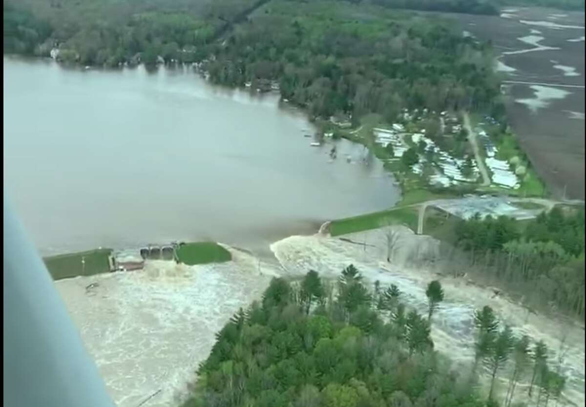 The Tittabwassee River spills over the damaged Edenville Dam in this screenshot of video shot by Ryan Kaleto on Tuesday, May 19 2020.