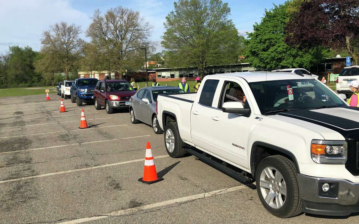 A line of motorists wait their turn to receive their free bag of five disposable masks.