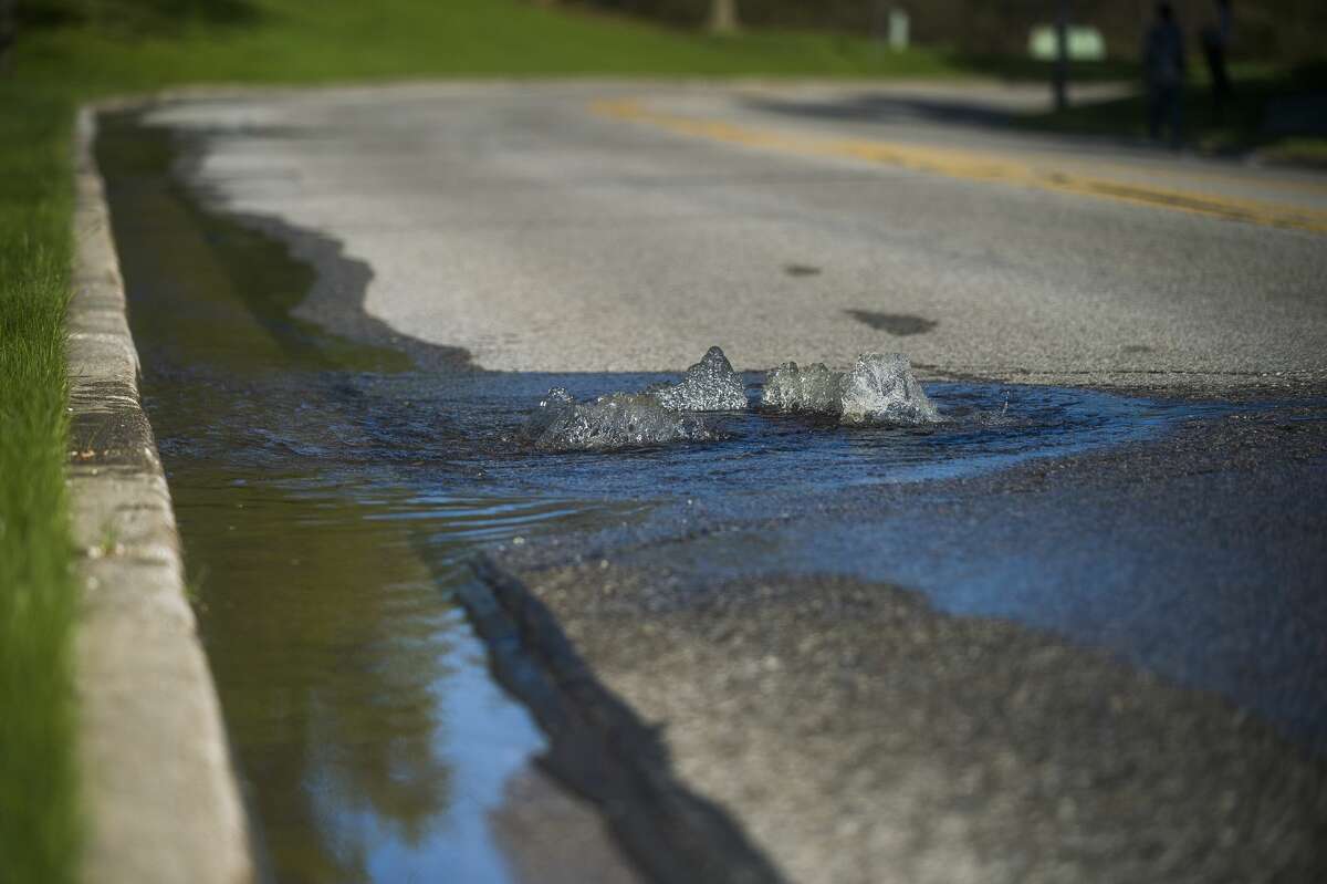Water flows up through sewer grates on St. Andrews Road near Eastman Avenue as floodwater rises in Midland Wednesday, May 20, 2020. (Katy Kildee/kkildee@mdn.net)