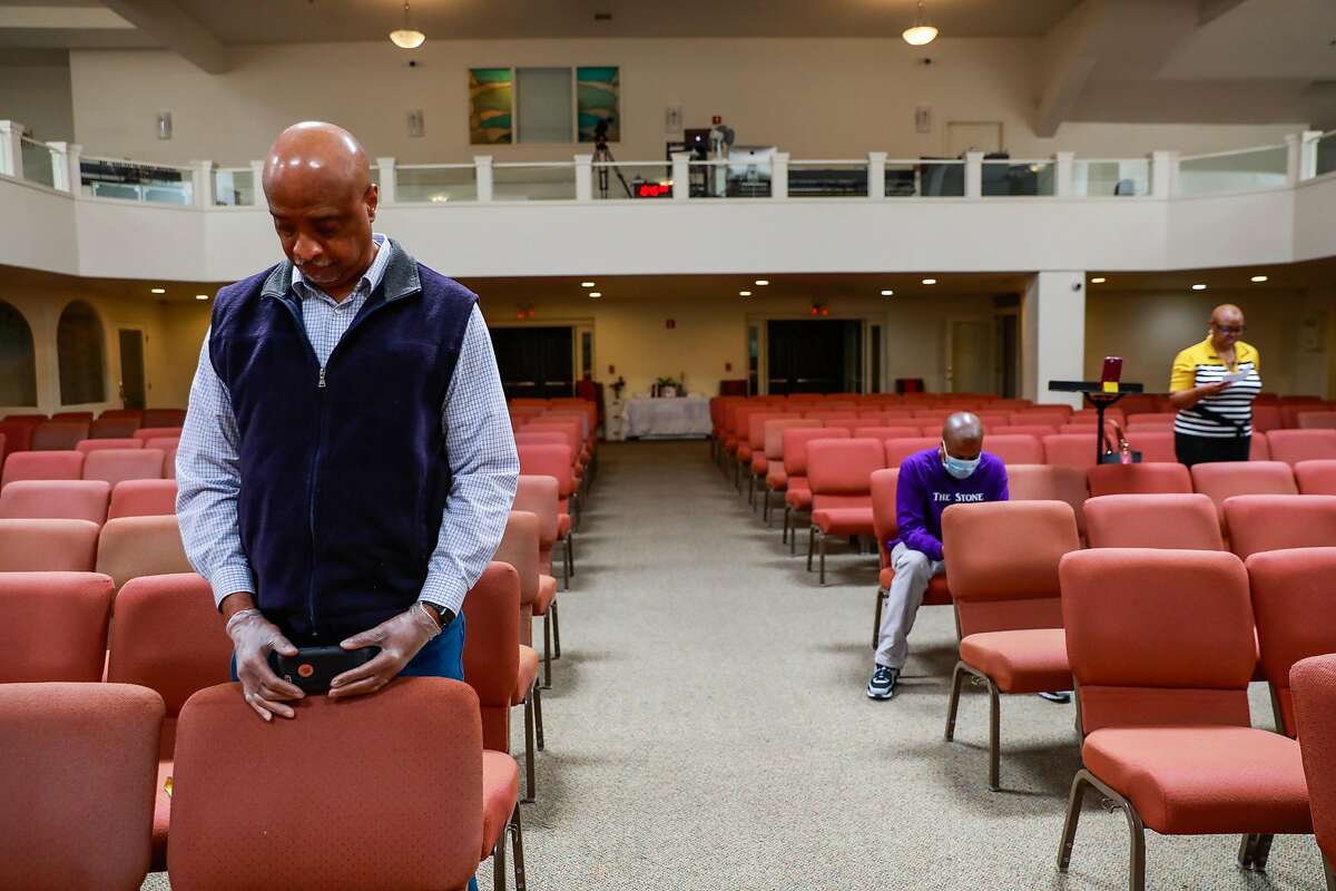 Damone White (center) and his wife Crystal White (right) during the virtual church service at Cornerstone Missionary Church in the Bayview district on Sunday, May 10, 2020 in San Francisco, California. One of the congregants, Tessie Henry, contracted coronavirus from a funeral at the church and later died.
