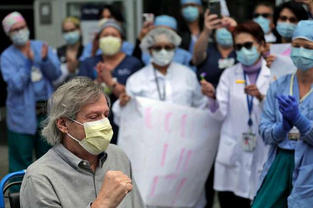 Ronald Jay Temko pumps his fist as is cheered by family, friends and medical personnel as he is discharged from UCSF Mount Zion Hospital, after being hospitalized for over 61 days with COVID-19 in San Francisco. Calif., on Wednesday, May 20, 2020. Temko was in a coma for 21 days, on a ventilator for 34 days, and had a feeding tube for 40 days. Despite all the odds, he is now up and walking, as mentally sharp as ever, and beyond grateful to be alive. He will now get to walk his daughter down the aisle, hold his new baby granddaughter, and teach his grandson how to play golf.