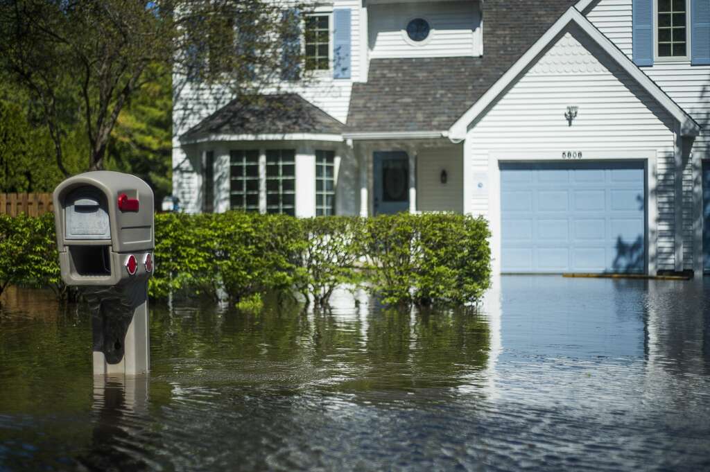 <p>Floodwater covers the street on Sturgeon Avenue Wednesday afternoon, May 20, 2020. (Katy Kildee/kkildee@mdn.net)</p>