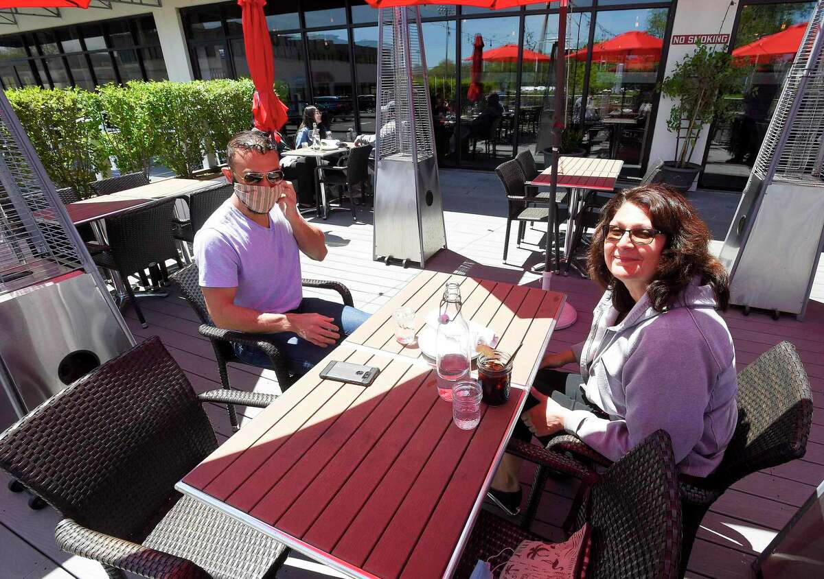 Stavros Begetis of Stamford and his mother Connie Begetis prepare to enjoy a meal at Tomato Tomato in Stamford, Connecticut on May 20, 2020. The two were among the first customers to enjoy the return of outdoor dining, as businesses in the area begin to reopen following a local and state wide shutdown to patrons dining in response to the COVID-19 Pandemic.