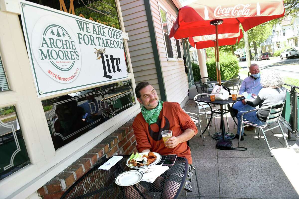 Rob Rintoul of Hamden enjoys Buffalo wings and a beer at Archie Moore's Bar & Restaurant's outdoor seating on Willow Street in New Haven on the first day of the phased reopening of businesses in Connecticut on May 20, 2020.