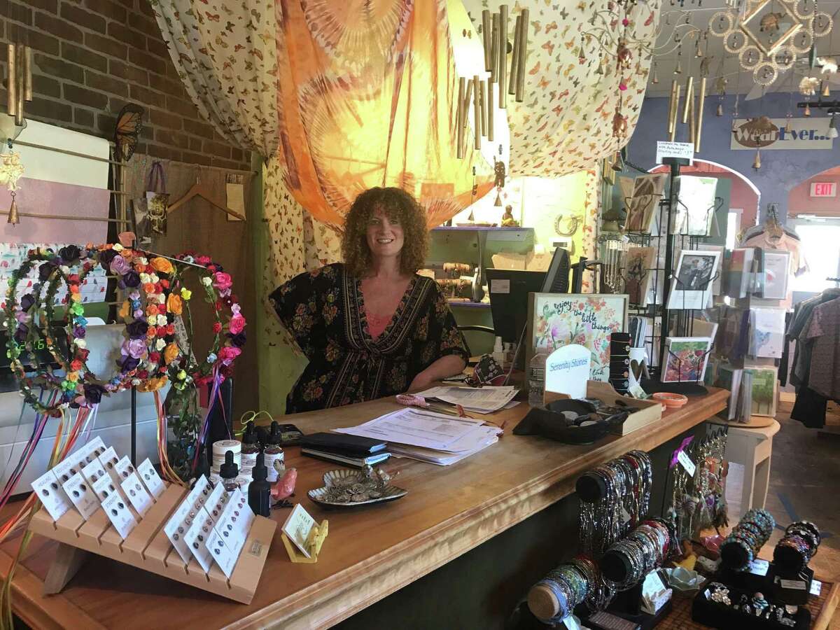 Flutterby owner Beth O'Bymchow stands in her store, which reopened Wednesday under the state's guidelines. Employees and customers are required to wear masks when shopping and interacting.