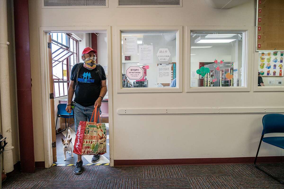 CJ Peoples and his dog, Mister, check in to Project Open Hand to get groceries in San Francisco on Wednesday, May 20, 2020.