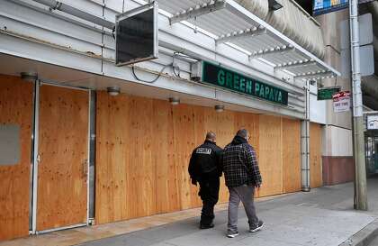 Plywood boards cover the windows at Green Papaya restaurant in San Francisco, which relied on foot traffic from the Moscone Center before shelter-in-place began.