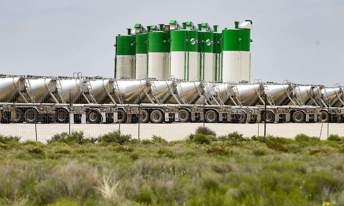 Oil silos and tanker trucks parked at TSS lot near Odessa, Texas on Monday, April 27, 2020.