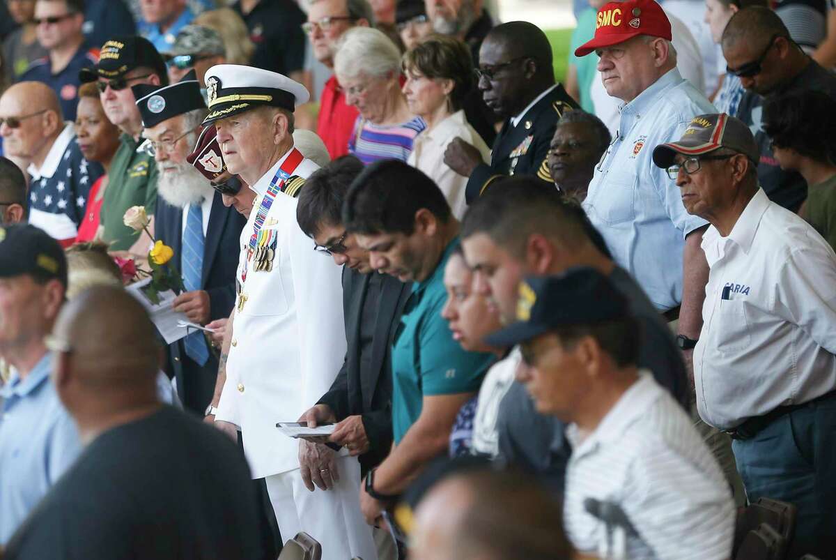 A crowd of mostly veterans stand during the Memorial Day Ceremony at the Houston National Cemetery on Monday, May 27, 2019.