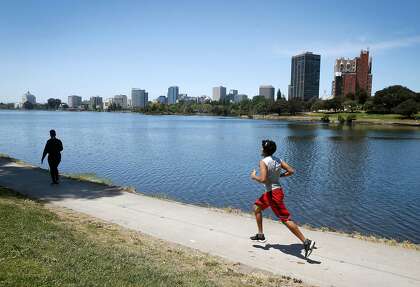 People walk and run around Lake Merritt in Oakland this month. Lake Merritt has been a popular destination during the coronavirus pandemic despite shelter-in-place orders.