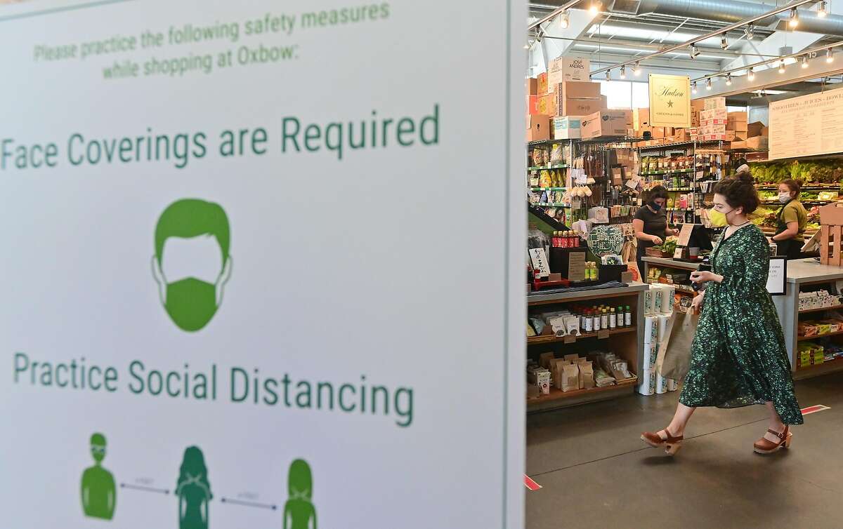 A shopper walks through Oxbow Market in Napa, California on May 20, 2020. Taking advantage of Napa's liberalized shelter-in-place rules, some restaurants have begun to fully reopen with new safety requirements in place.
