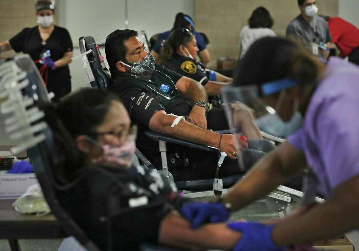 Jerry Gallegos, center, donates blood Thursday, May 20, 2020, during the South Texas Blood and Tissue Center’s drive at the Alamodome to shore up the region’s blood supply. The blood drive will continue through Saturday.