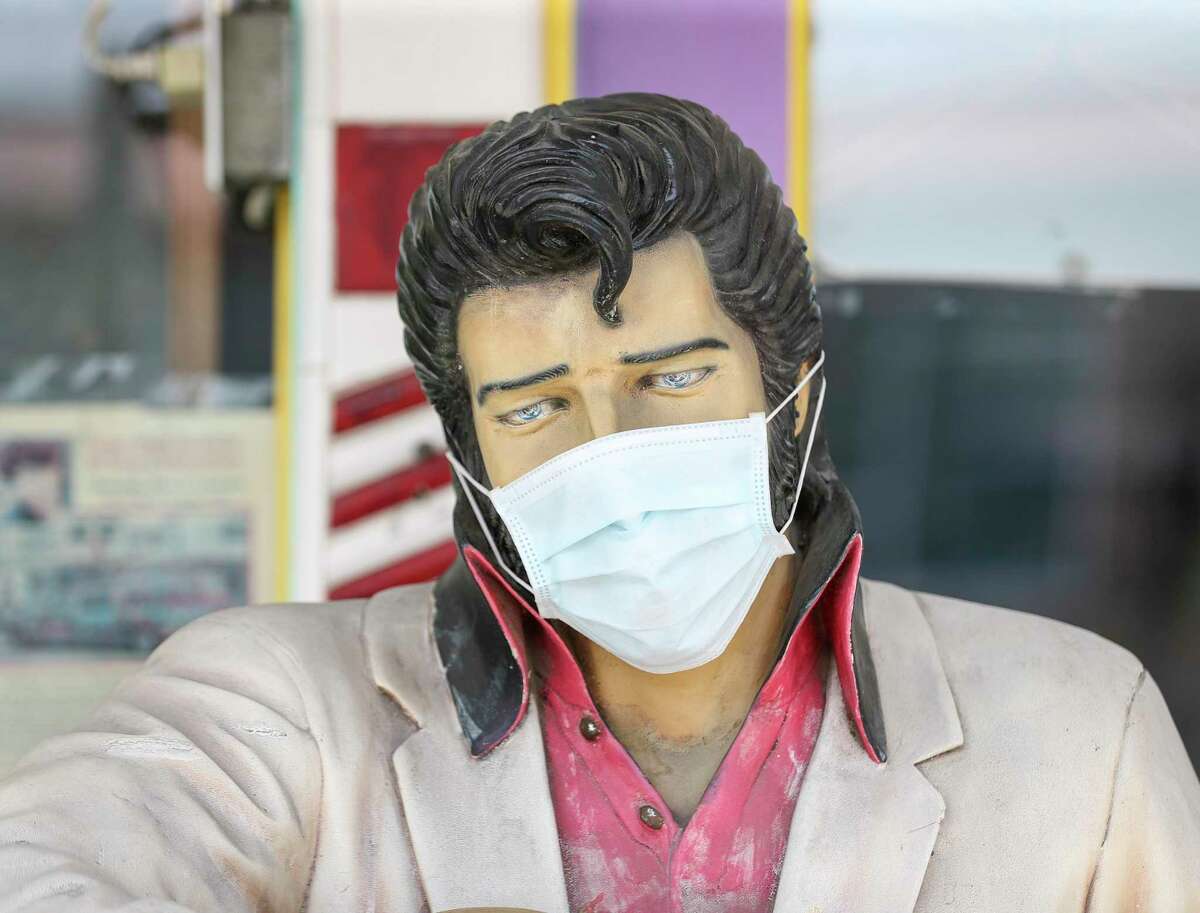 An Elvis statue with a mask, photographed Thursday, May 21, 2020, along 19th Street in the Heights neighborhood in Houston.