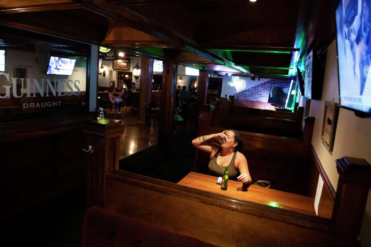 Jessica Ford takes a shot of Jose Cuervo tequila at The Winchester pub a few moments after the establishment opened its doors for the first legal drinks in a San Antonio bar in nearly two months at 12:01 am on Friday.
