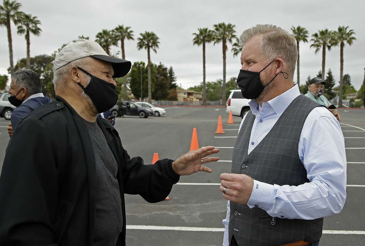 Bishop Bob Jackson, left, of Acts Full Gospel Church, gestures to Pastor Jim Domen, of Church United in Newport Beach, Calif., after a media conference in the parking lot of the church on Thursday, May 14, 2020, in Oakland, Calif. Jackson has joined a network of California pastors in uniting to open church doors across the state on May 31, 2020, the Day of Pentecost, with or without the permission of the governor. (AP Photo/Ben Margot)