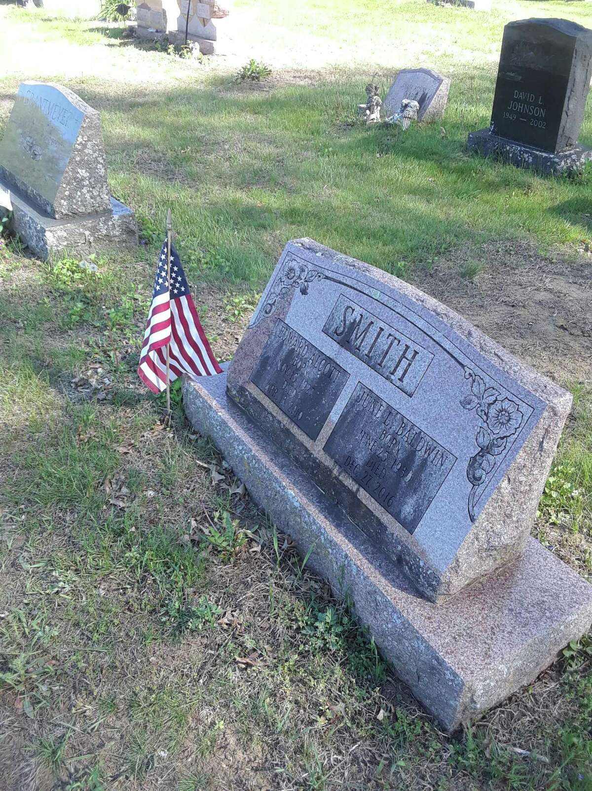 Veterans groups and volunteers spent time in local cemeteries replacing flags on veterans' graves in preparation for Memorial Day. Above, a gravestone at Forest View Cemetery in Winsted.