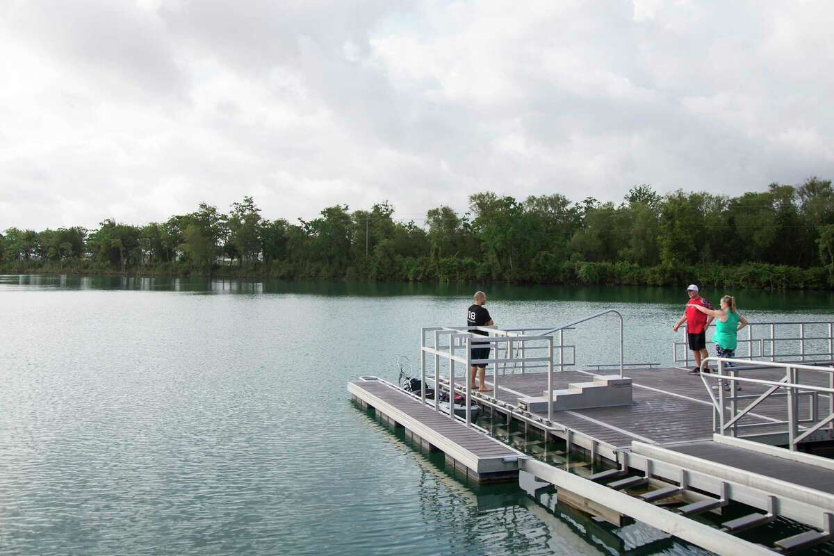 Drew Price, left, talks to Virgil Mikeska and Jana Giovannini on a dock at Lake Friendswood Park on Friday, May 22, 2020 in Friendswood.