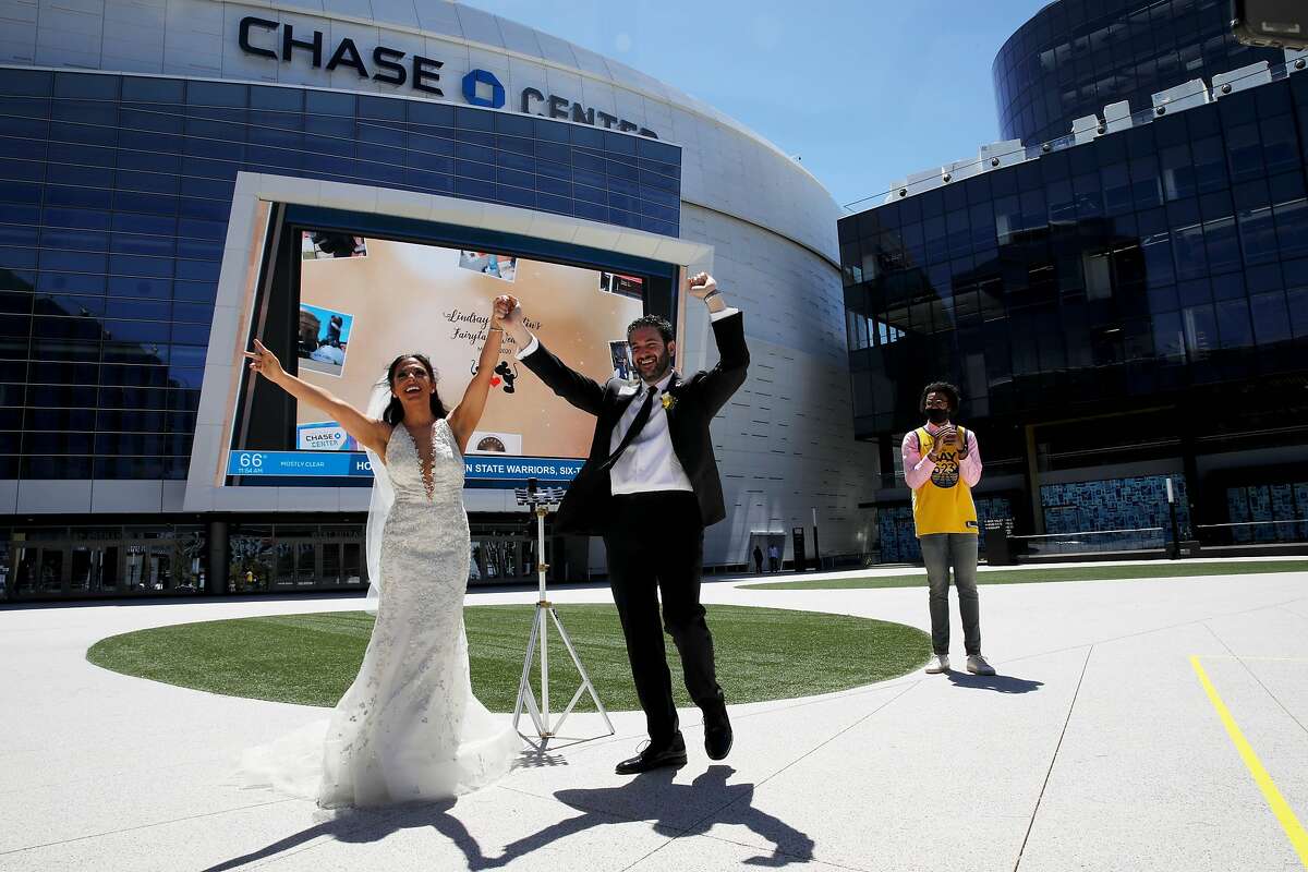 Lindsay and Dustin Schneider celebrate during their wedding at the Chase Center, with Golden State Warriors rookie Jordan Poole as their witness in San Francisco, Calif., on Saturday, May 23, 2020. Rebeca Delgadillo (CQ'D) officiated the ceremony. The couple had been scheduled to get married on May 23 in Orlando (big Disney fans). Due to coronavirus those plans were scrapped, so they approached the Warriors about getting married outside Chase. The Warriors said yes.