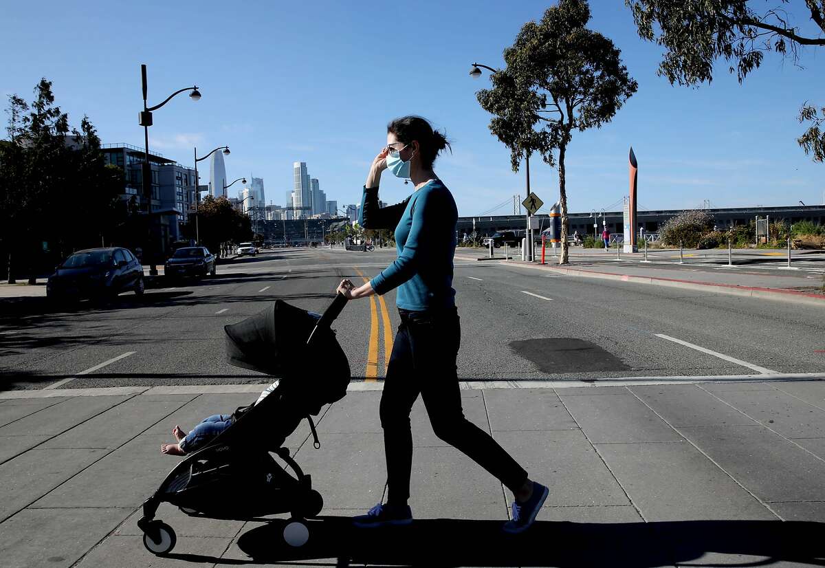 Allison Bond, a local infectious disease doctor, walks her 10-month-old son along Mission Bay Blvd. in San Francisco, Calif., on Saturday, May 23, 2020. San Francisco's health orders are long on specifics for businesses, but short on specifics for regular people.