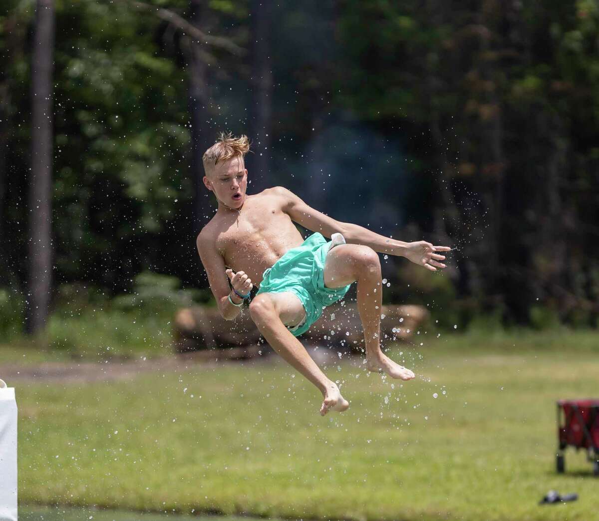 A boy prepares to land in a lake at Chadillac’s Ranch in Conroe after sliding off a water slide, Sunday, May 24, 2020. Chadillac’s Ranch postponed their usual Spring Break opening until Memorial Day weekend with restrictions.