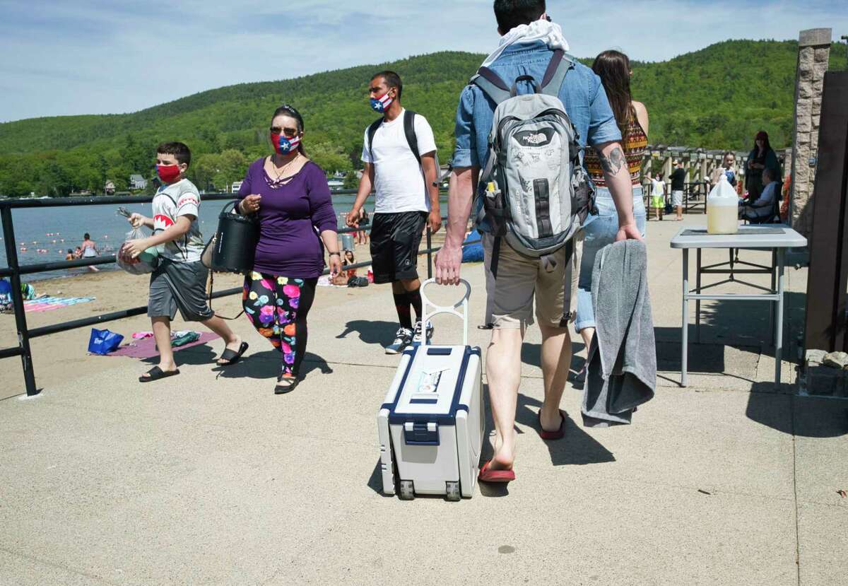 People make their way around Million Dollar Beach on Sunday, May 24, 2020, in Lake George, N.Y. New rules are in effect to help stop the spread of coronavirus. People must wear masks when moving around the beach but masks can be removed when swimming or when sitting on the sand. (Paul Buckowski/Times Union)