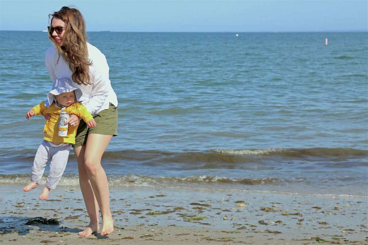 Christine Peterson of Westport and her daughter Lila, 15 months, play by the water at Compo Beach on Sunday, May 24, 2020, in Westport, Conn.