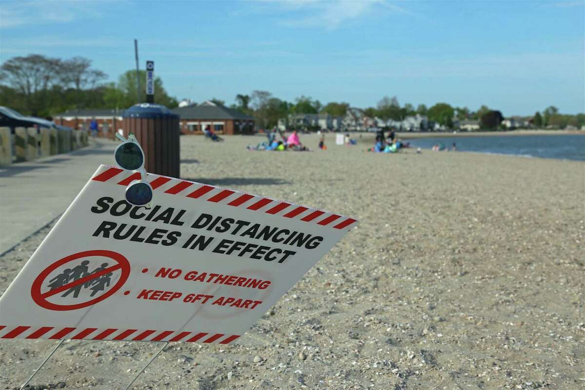 One of several signs stretching along the sand at Compo Beach on Sunday, May 24, 2020, in Westport, Conn.
