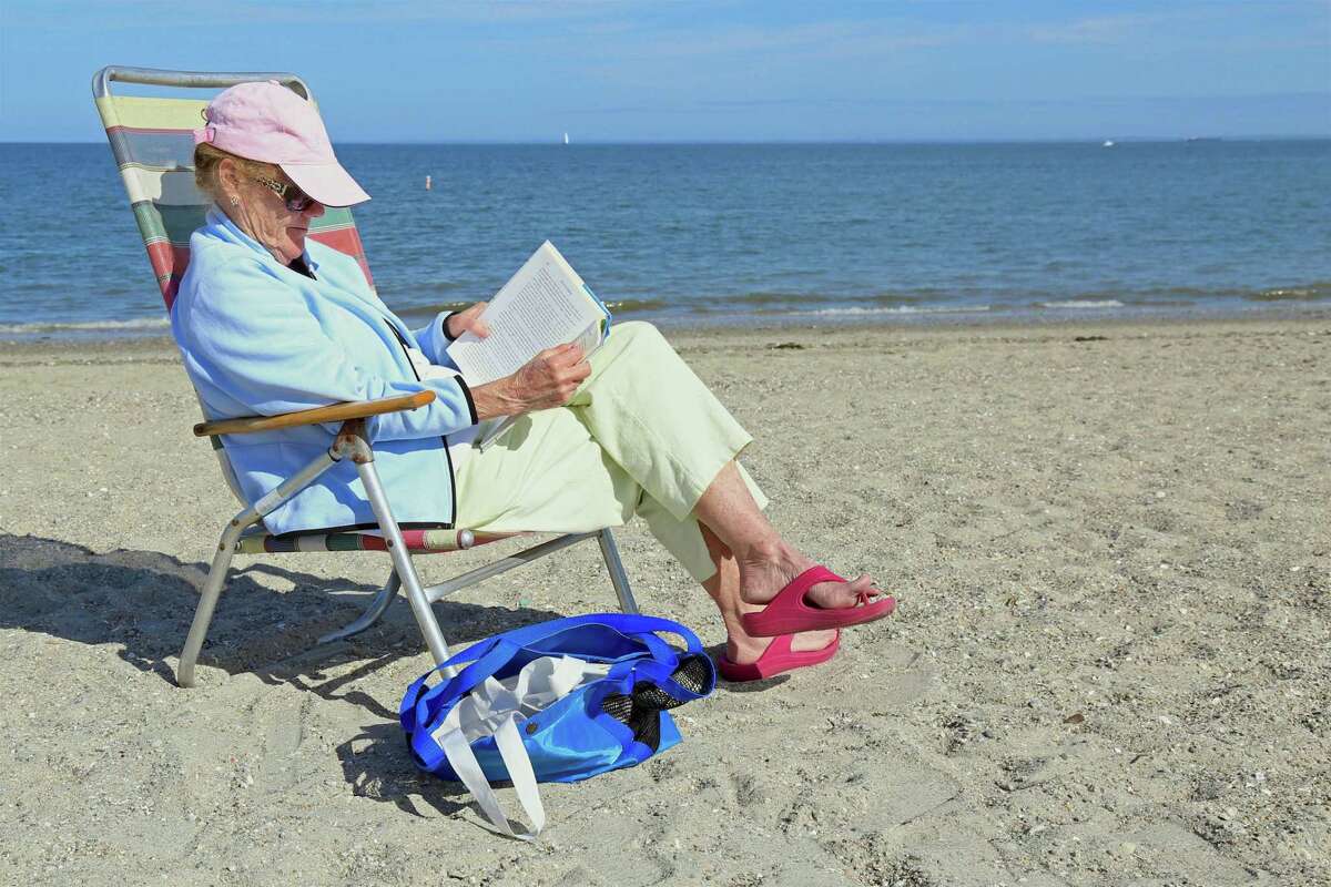 Clare Clark of Westport does some al fresco reading at Compo Beach on Sunday, May 24, 2020, in Westport, Conn.