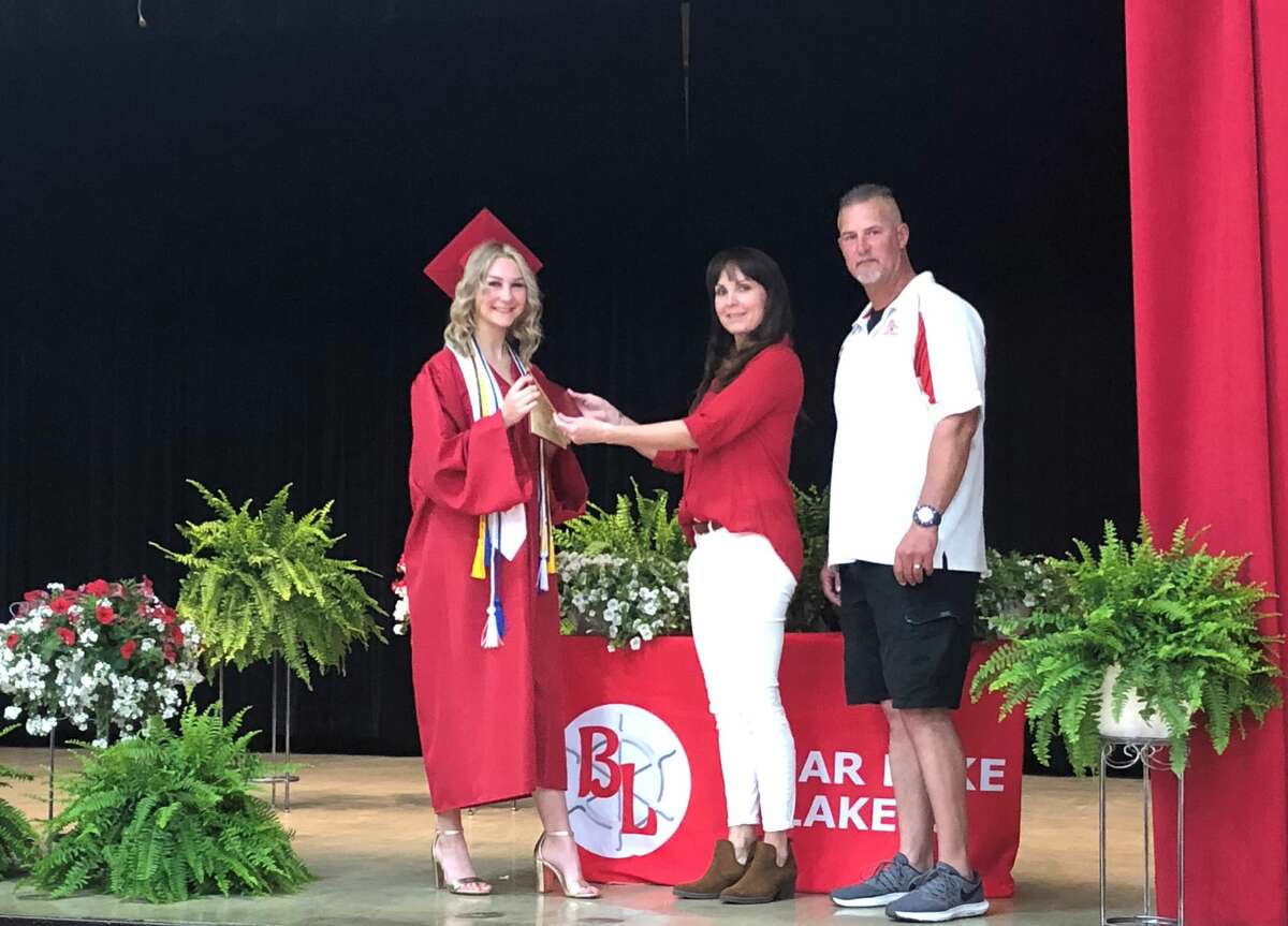 Shaely Waller accepts her diploma from her parents Alyssa and Garrett on stage Saturday.