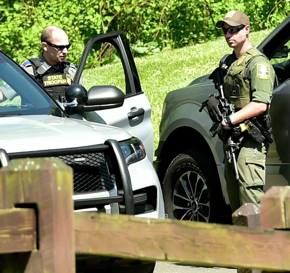 A Connecticut Department of Energy and Environmantal Protection officer, right, talks with a state trooper Sunday during the search for suspected murderer Peter Manfredonia, 23, described as armed and dangerous Sunday morning at Osbornedale State Park in Derby after a stolen vehicle linked to the suspect was found on Hawthorne Avenue near Cullens Hill Road in Derby. The area borders Osbornedale State Park.The discovery launched an extensive search of the park and on local streets and in neighborhoods near Osbornedale and Roosevelt Drive where law enforcement secured another crime scene thought to be connected to Manfredonia. State Police said Manfredonia is believed to be armed with pistol and long guns. Manfredonia is wanted in a homicide and serious assault in northeastern Connecticut.