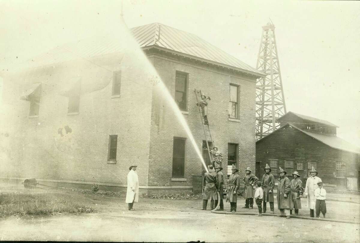 The Manistee Fire Department holds a firefighting drill in this early 1900 photograph.