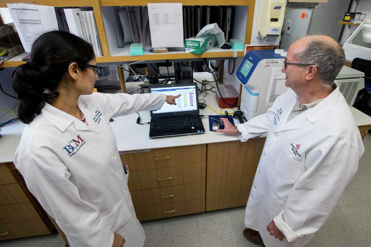 Vasanthi Avadhanula, Ph.D, shows Dr. Pedro Piedra, coronavirus test results in a lab on Thursday, April 9, 2020 at Baylor College of Medicine in Houston. BCM is working on an experimental therapy transfusing the blood plasma of people who’ve recovered from COVID-19 into patients fighting the disease. Baylor and the Gulf Coast Regional Blood Center are partnering to make the potentially therapeutic plasma available to hospitals that get the Food and Drug Administration’s permission to transfuse it into patients. Baylor will screen and test interested donors and the blood center will collect the plasma and get it to hospitals.