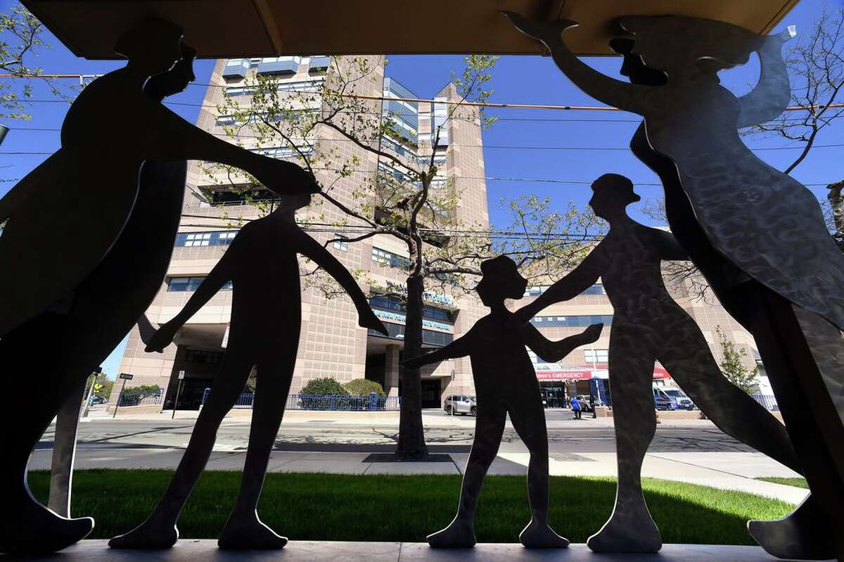 Yale New Haven Children's Hospital can be seen in the background through a silhouetted sculpture at the Ronald McDonald House of Connecticut in New Haven on May 13, 2020.