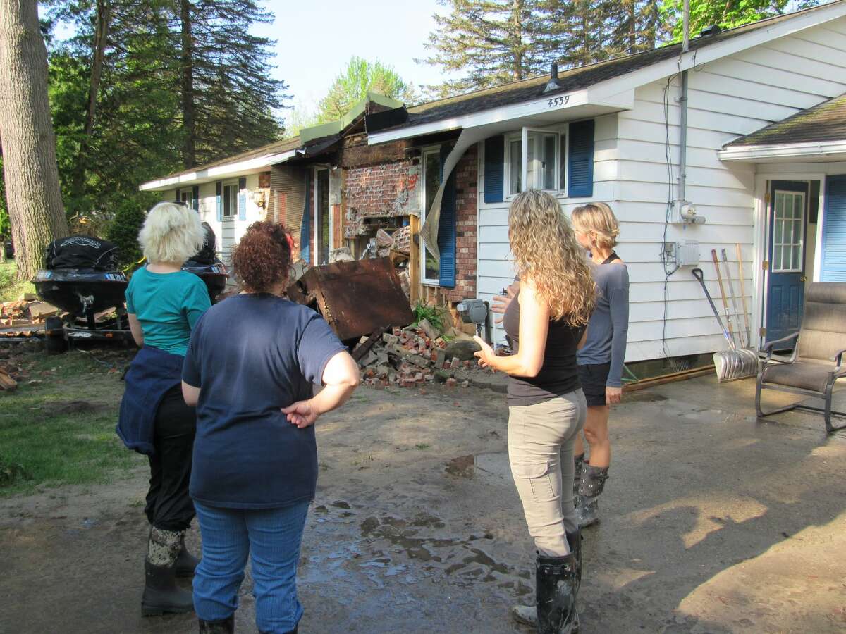 Left to right, Annette Glenn, Jeanette Snyder, Lisa McGaugh and Sara Ladwin observe the damage done to Ladwin's lakefront home by flooding earlier that week, on May 23, 2020 in Sanford. (Mitchell Kukulka/Mitchell.Kukulka@mdn.net)