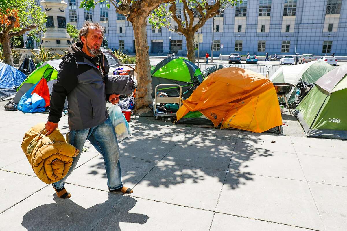 Homeless man Larry Gaspar walks by an encampment on Fulton Street on Wednesday, May 6, 2020 in San Francisco, California.