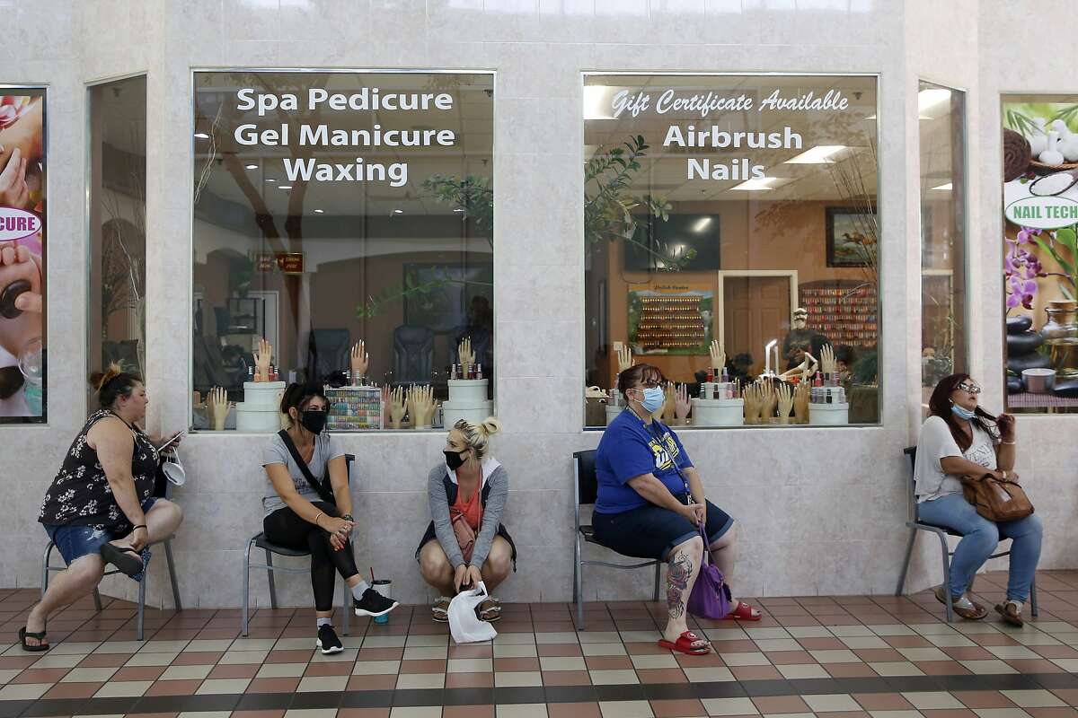 FILE - In this May 6, 2020, photo customers wait to get their nails done at the Nail Tech salon in the Yuba Sutter Mall in Yuba City.