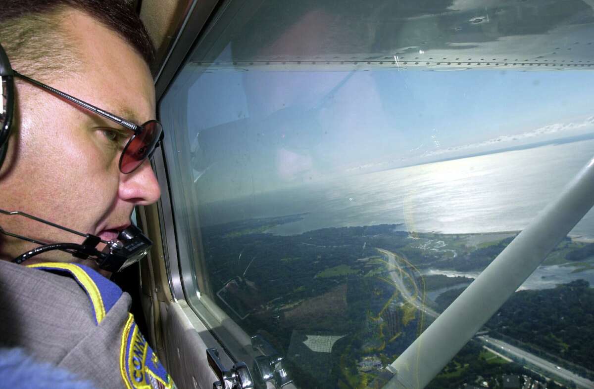 State trooper Gene Baron spots speeding motorists from 2,000 feet while on patrol above I-95 in a single-engine Cessna in August 2001. Baron uses a timing device to identify speeding cars and radios their descriptions to troopers waiting in patrol cars on the roads below.