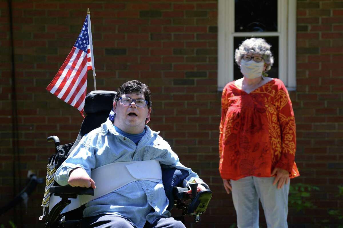 Penny Barsch, of Meriden, stands six feet away from her son, Shane Sessa, in the back yard of the group home where he lives in Portland. When Sessa, who has cerebral palsy, was hospitalized recently for surgery, Barsch was prohibited from accompanying him due to hospital restrictions in place since the onset of the COVID-19 pandemic.
