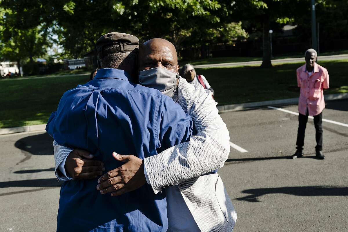 Paul Redd, center, hugs his cousin Danny Cotton after being released from the Department of Correction and Rehabilitation's California Medical Center after serving a total of 44 years in prison and more than 25 in solitary confinement, as family members gather at Al Patch Park in Vacaville, Calif, on Thursday, May 21, 2020.