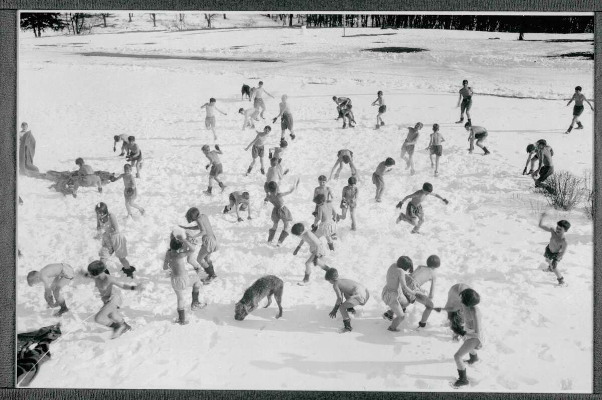 Boys and girls play in the snow while scantily clad at the Undercliff Sanatorium in Meriden.