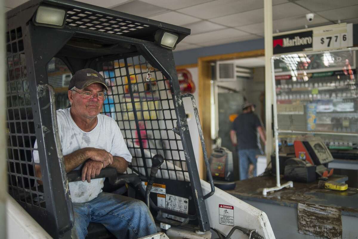 Mark Pelton pauses as other volunteers prepare a pile of debris for him to push from the interior of Poseyville Party Store with a backhoe Wednesday, May 27, 2020 in Midland. (Katy Kildee/kkildee@mddn.net)
