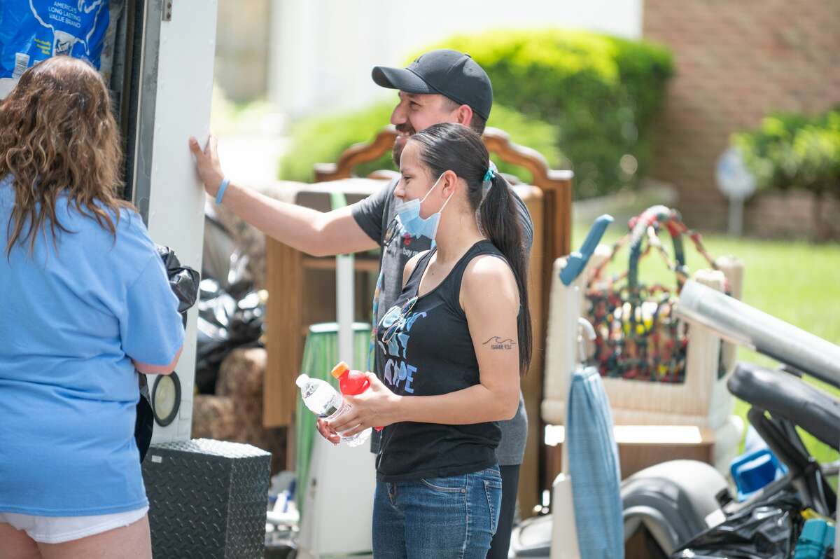 An effort organized by 2|42 Community Church provides Midland residents working to clean up flood-damaged homes with cleaning supplies, gloves, water, and hot meals from the Makin' Bacon food truck Wednesday, May 27, 2020. (Adam Ferman/for the Daily News)