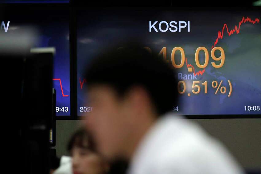Currency traders watch computer monitors near the screen showing the Korea Composite Stock Price Index (KOSPI) at the foreign exchange dealing room in Seoul, South Korea, Wednesday, May 27, 2020. Major Asian stock markets have declined as US-Chinese tension over Hong Kong competes with optimism about recovery from the coronavirus pandemic.(AP Photo/Lee Jin-man)