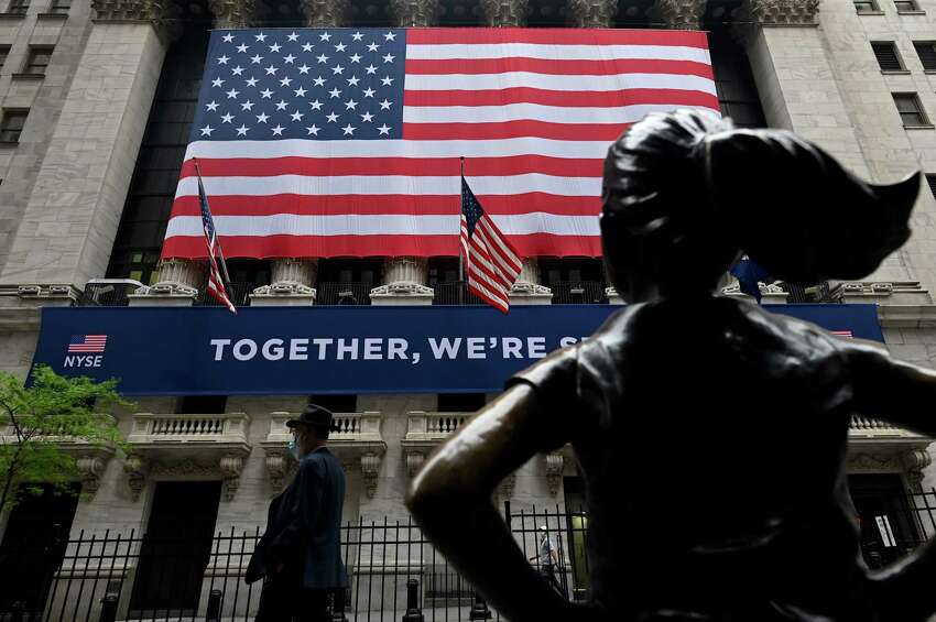 (FILES) In this file photo a man passes the building before the opening bell at the New York Stock Exchange (NYSE) on May 26, 2020 on Wall Street in New York City. - Wall Street stocks opened higher on May 27, 2020 on continued optimism about the reopening of the US economy as investors shrug off rising tensions between Washington and Beijing. Shortly after the opening bell, the Dow Jones Industrial Average stood at 25,338.80, up 1.4 percent. (Photo by Johannes EISELE / AFP) (Photo by JOHANNES EISELE/AFP via Getty Images)