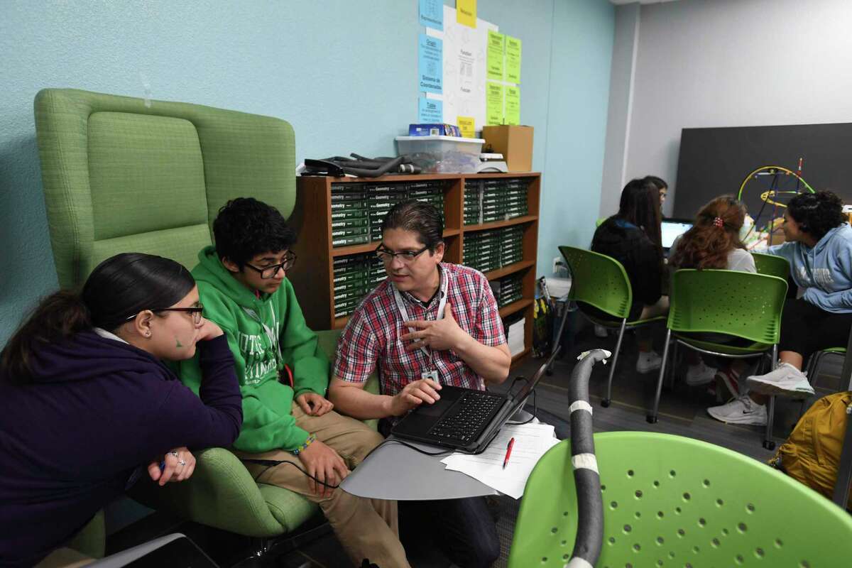 Mya Hernandez, left, and Aiden Elizondo listen as math teacher Oscar Garcia explains a solution at CAST Med High School on Friday, Nov. 22, 2019. The school offers a dual language program, as well as a curriculum that prepares students for careers in the medical field.