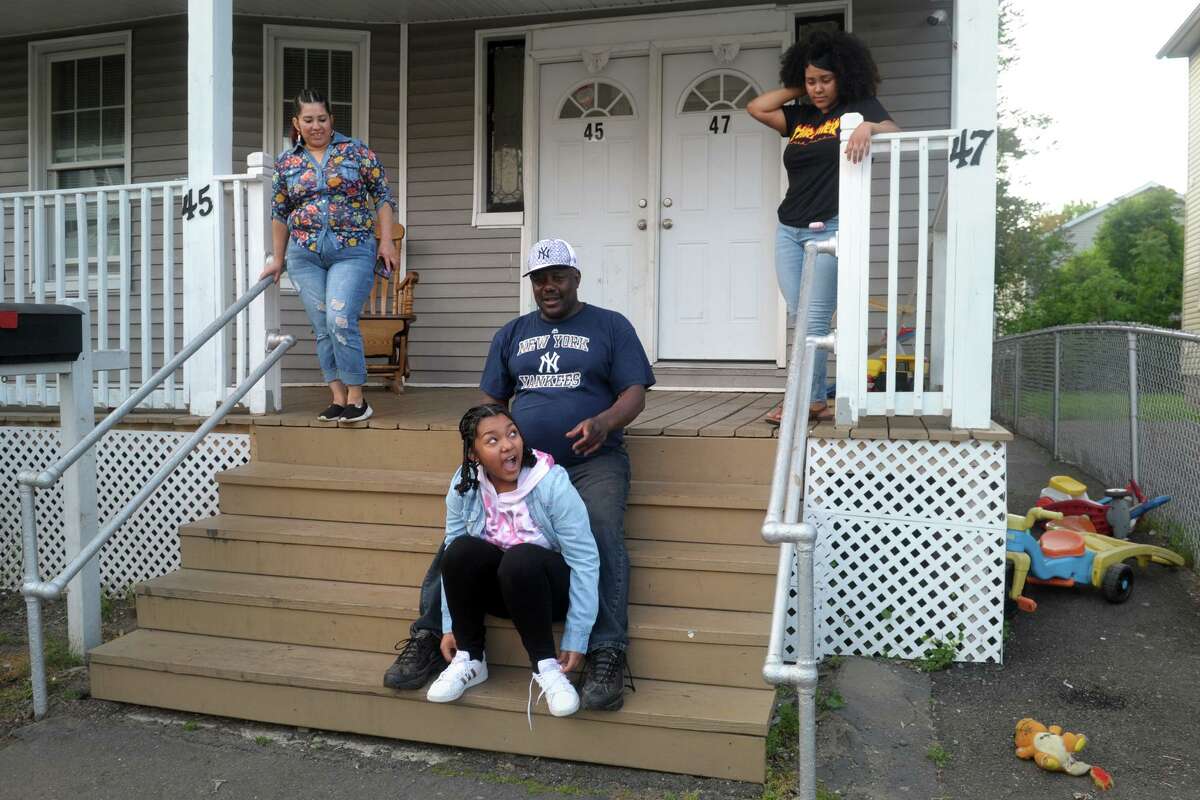 Victor Marin sits on the front steps of his home with his wife, Nidia, left, and daughters Andrea, center, and Melissa, right, in Bridgeport, Conn. May 28, 2020. The family recently learned that they are not eligible for a federal stimulus check since Victor is an undocumented immigrant.