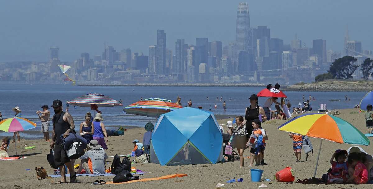 People congregate on Robert W. Crown Memorial State Beach with the San Francisco skyline as a backdrop, Tuesday, May 26, 2020, in Alameda, Calif. The U.S. National Weather Service has issued a heat advisory for the Bay Area through Thursday, May 28, 2020.