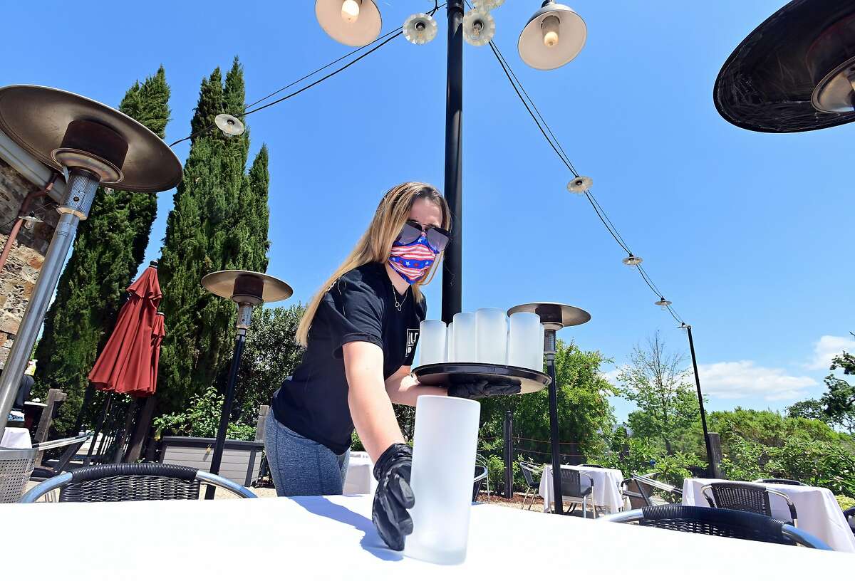 Employee Bryce Gagne sets up candles as workers prepare Cole's Chop House for on-site dining in Napa, California on May 20, 2020. Taking advantage of Napa's liberalized shelter-in-place rules, Cole's is reopening its dining room for customers with new safety requirements in place.