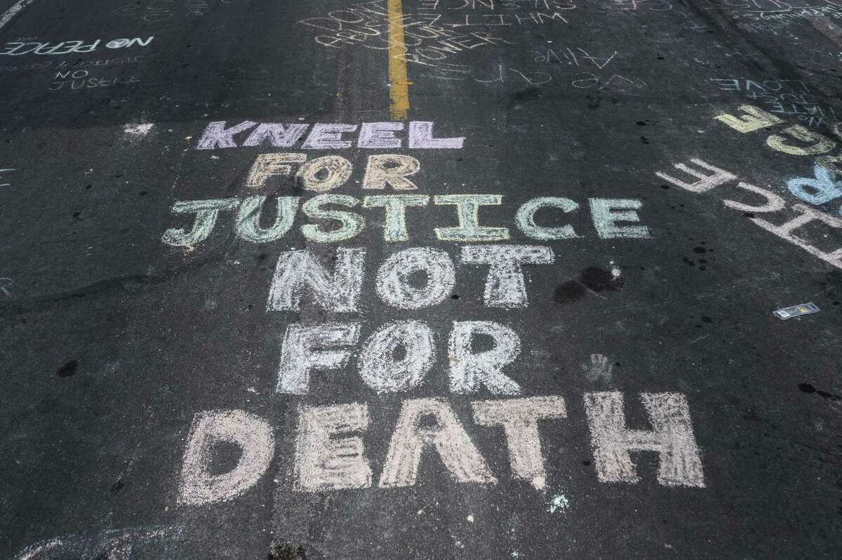 MINNEAPOLIS, MN - MAY 28: "Kneel for Justice not for Death" is written on the road outside the Cup Foods, where George Floyd was killed in police custody, on May 28, 2020 in Minneapolis, Minnesota. People have gathered at the site since Floyd was killed earlier this week. (Photo by Stephen Maturen/Getty Images)