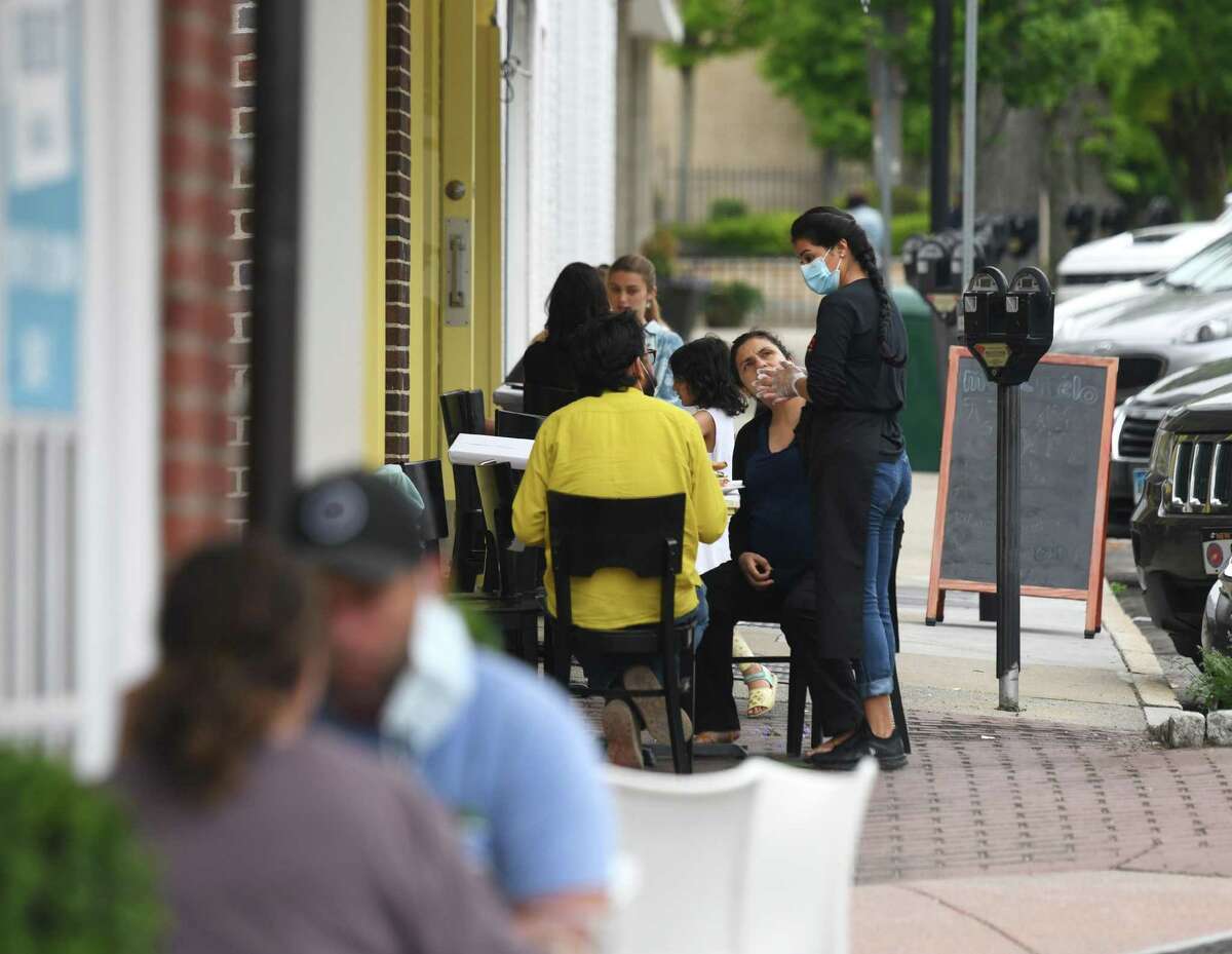 A crowd dines outside at Meli-Melo on Greenwich Avenue in Greenwich, Conn. Thursday, May 28, 2020. The southern end of Greenwich Avenue from Arch Street to Railroad Avenue will be closed off to vehicular traffic to be used as an area for pedestrians and outdoor dining.